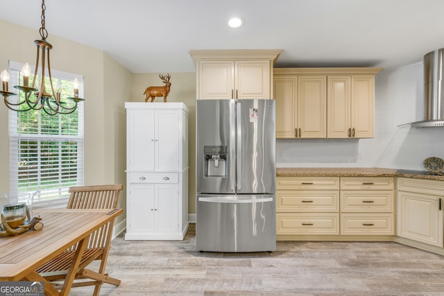 kitchen with light wood-type flooring, a notable chandelier, hanging light fixtures, stainless steel fridge with ice dispenser, and cream cabinetry