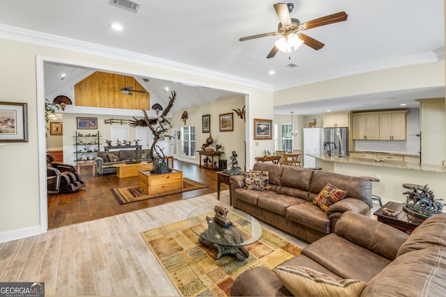 living room featuring lofted ceiling, wood-type flooring, crown molding, and ceiling fan