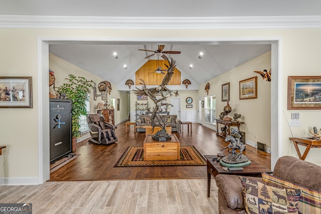 living room with ornamental molding, lofted ceiling, ceiling fan, and wood-type flooring