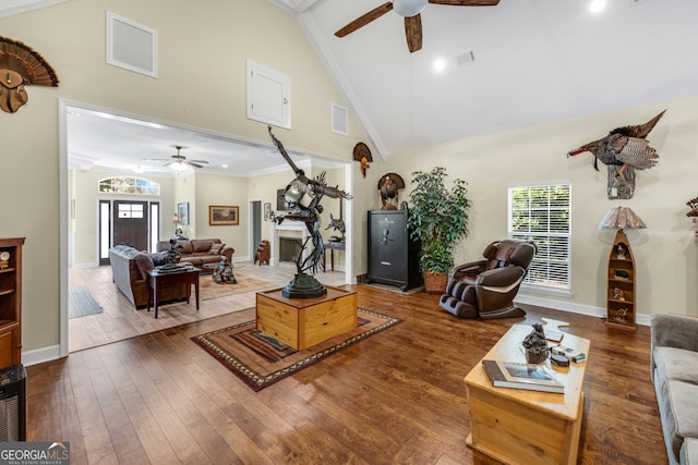 living room featuring ceiling fan, hardwood / wood-style flooring, ornamental molding, and high vaulted ceiling