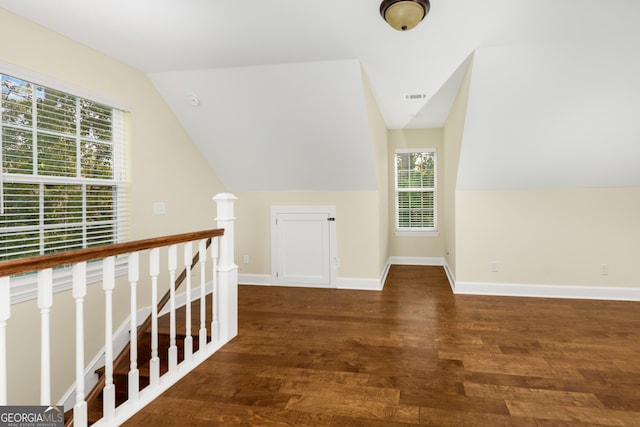 bonus room with dark wood-type flooring and vaulted ceiling