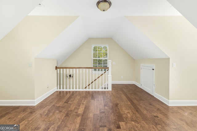 additional living space with vaulted ceiling and dark hardwood / wood-style floors