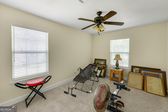 workout area featuring ceiling fan and light carpet