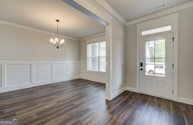 foyer with a chandelier, dark wood-type flooring, crown molding, and a healthy amount of sunlight