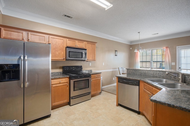 kitchen featuring appliances with stainless steel finishes, sink, a textured ceiling, pendant lighting, and crown molding