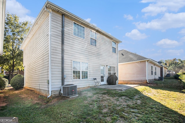 back of property with a patio, a yard, and central air condition unit