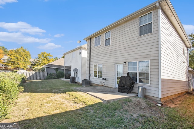 rear view of property featuring a patio area, central AC, and a lawn