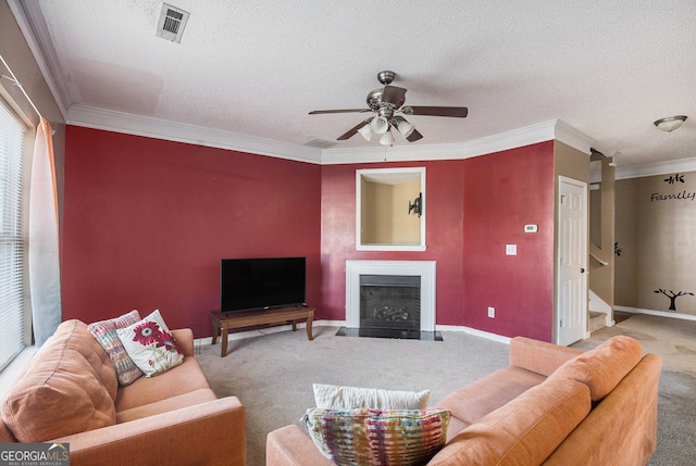 living room with ceiling fan, a textured ceiling, ornamental molding, and carpet floors