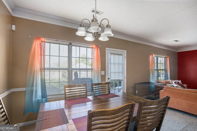 dining room with a textured ceiling, ornamental molding, and a chandelier