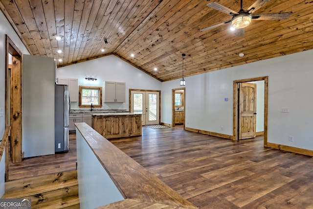 kitchen featuring decorative light fixtures, stainless steel refrigerator, dark hardwood / wood-style floors, and wooden ceiling