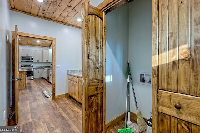 hall featuring dark hardwood / wood-style flooring and wooden ceiling