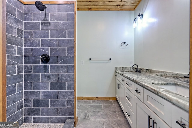 bathroom featuring tiled shower, vanity, tile patterned flooring, and wood ceiling