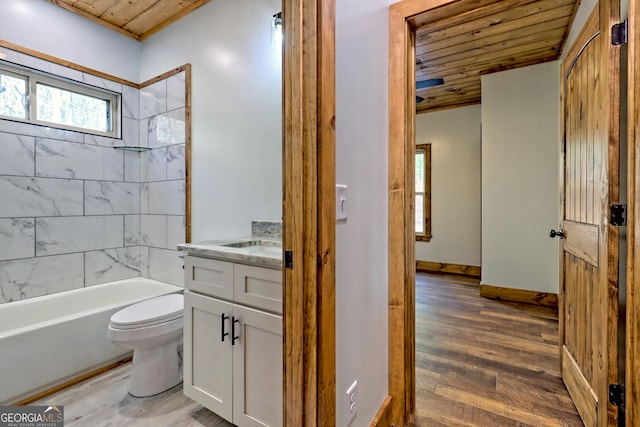 full bathroom featuring hardwood / wood-style floors, vanity, wooden ceiling, tiled shower / bath, and toilet