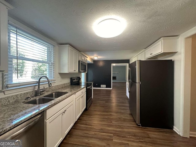 kitchen with white cabinets, sink, a textured ceiling, stainless steel appliances, and dark hardwood / wood-style flooring