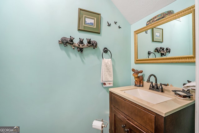 bathroom with vanity, a textured ceiling, and lofted ceiling