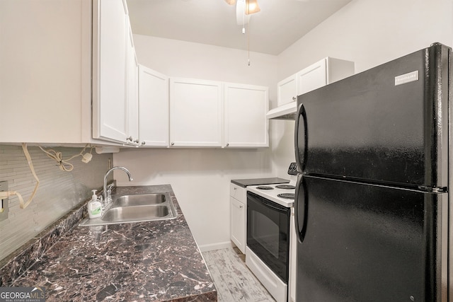 kitchen with white cabinets, premium range hood, white range with electric cooktop, black refrigerator, and sink