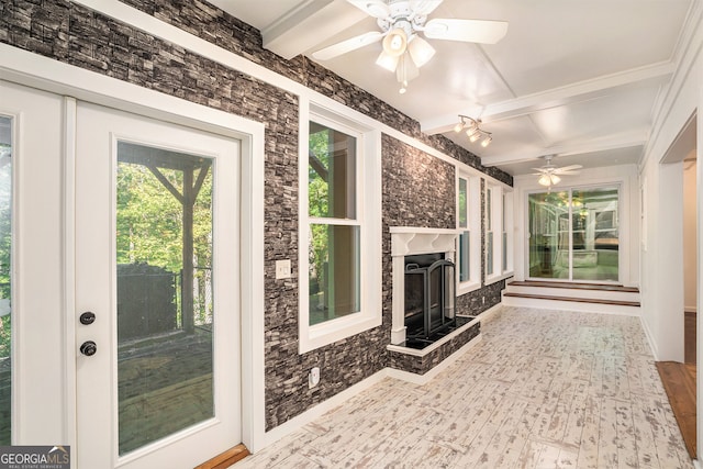 unfurnished sunroom with beam ceiling, a fireplace, and ceiling fan