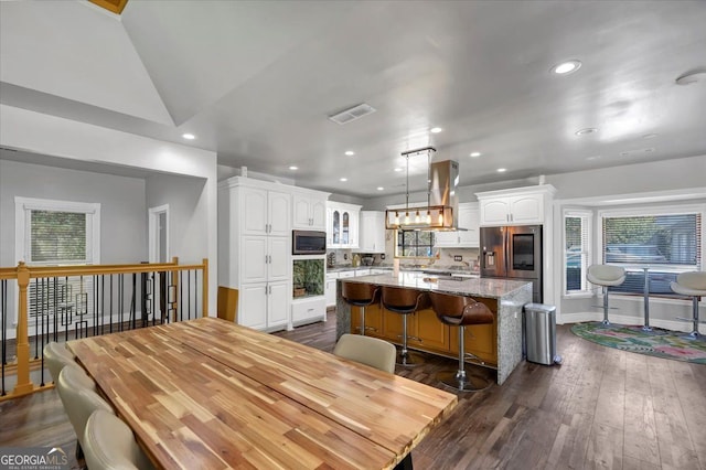 dining space featuring vaulted ceiling and dark hardwood / wood-style floors