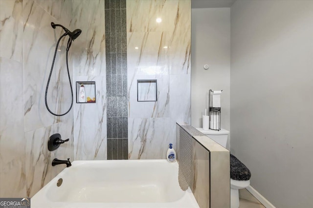 bathroom featuring tiled shower / bath and toilet