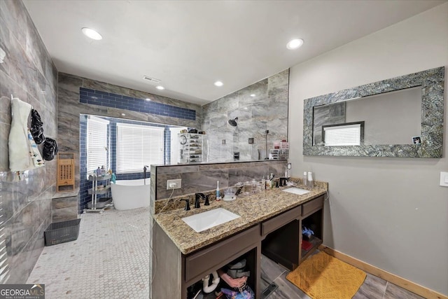 bathroom with vanity, shower with separate bathtub, and tile walls