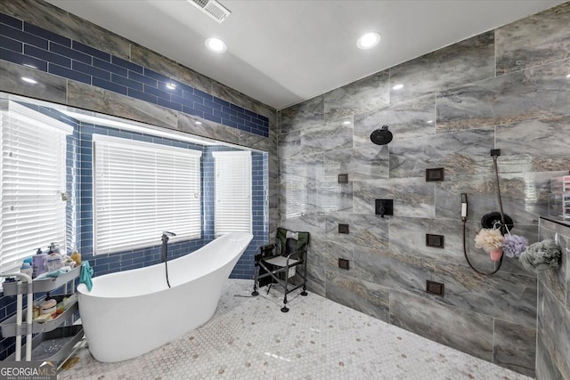 bathroom featuring tile walls, shower with separate bathtub, and tile patterned floors