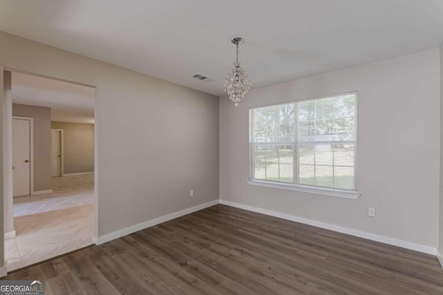 1983 Smithfield Ave, Ellenwood, GA 30294 - unfurnished dining area with wood finished floors, a chandelier, visible vents, and baseboards