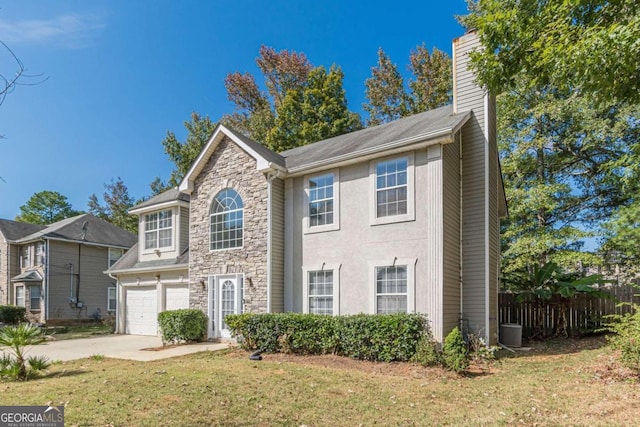 view of front of home featuring a front yard, a garage, and central AC