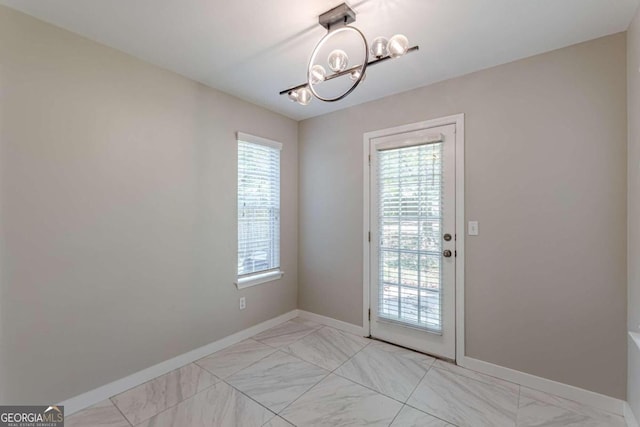 1983 Smithfield Ave, Ellenwood, GA 30294 - doorway to outside featuring baseboards, a notable chandelier, and marble finish floor