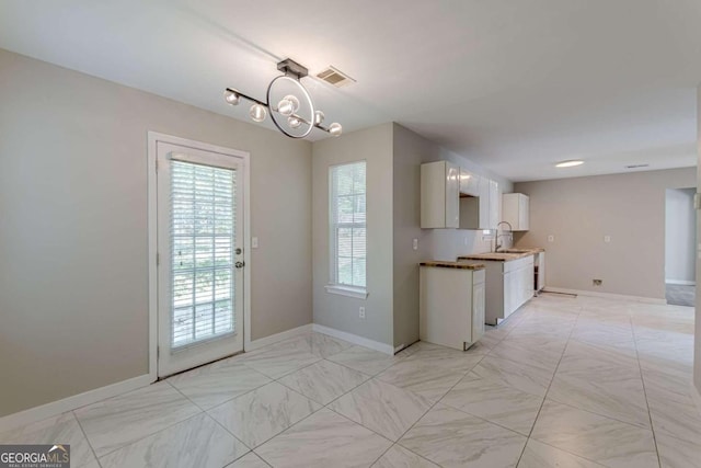 kitchen featuring an inviting chandelier, decorative light fixtures, and sink