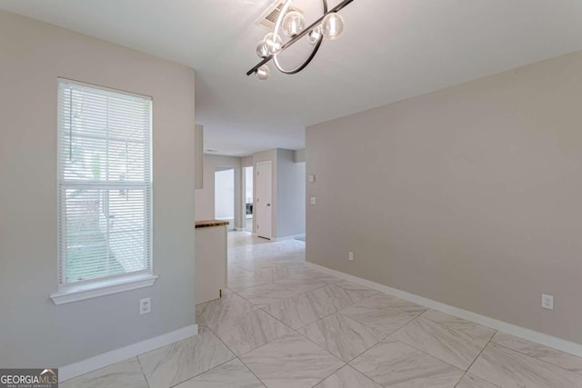 1983 Smithfield Ave, Ellenwood, GA 30294 - spare room featuring an inviting chandelier, marble finish floor, and baseboards