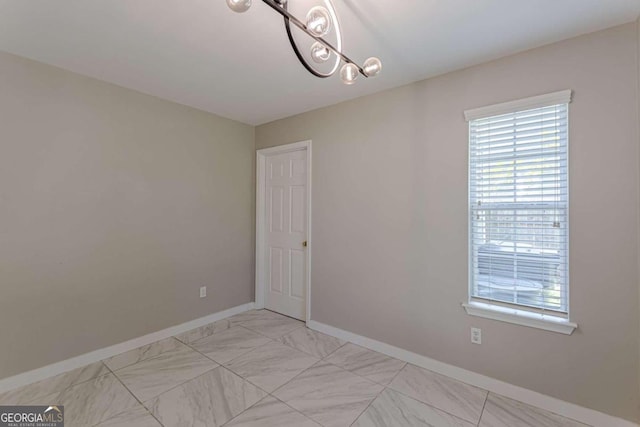 1983 Smithfield Ave, Ellenwood, GA 30294 - unfurnished room with marble finish floor, an inviting chandelier, and baseboards