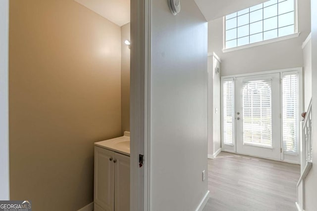 bathroom featuring vanity, a towering ceiling, and hardwood / wood-style flooring