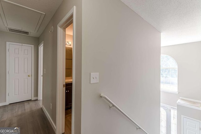 1983 Smithfield Ave, Ellenwood, GA 30294 - hall with a textured ceiling, an upstairs landing, visible vents, attic access, and wood finished floors