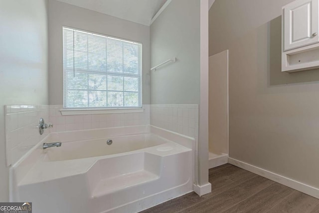 1983 Smithfield Ave, Ellenwood, GA 30294 - full bath featuring a garden tub, wood finished floors, and baseboards