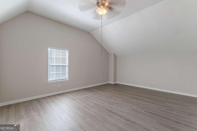 additional living space featuring ceiling fan, hardwood / wood-style floors, and vaulted ceiling