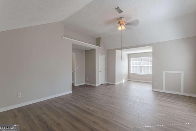 unfurnished living room featuring ceiling fan, lofted ceiling, hardwood / wood-style flooring, and a textured ceiling