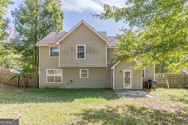 back of property with a yard and a patio