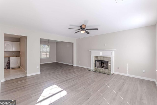 unfurnished living room featuring light wood-type flooring, a fireplace, and ceiling fan