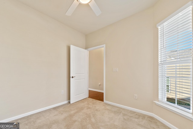 unfurnished room featuring ceiling fan and light colored carpet