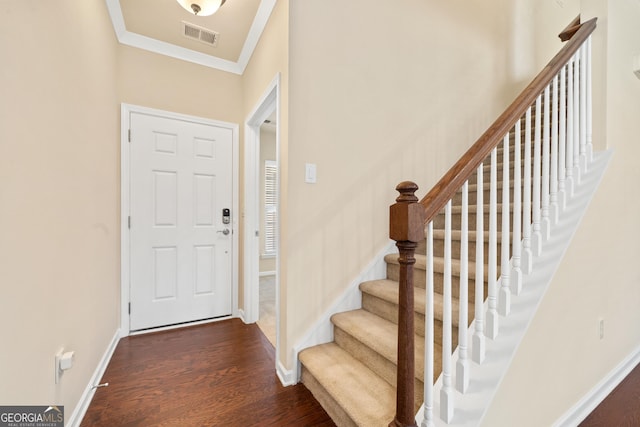 entryway with ornamental molding and dark wood-type flooring