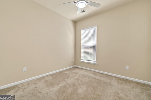 spare room with ceiling fan and light colored carpet