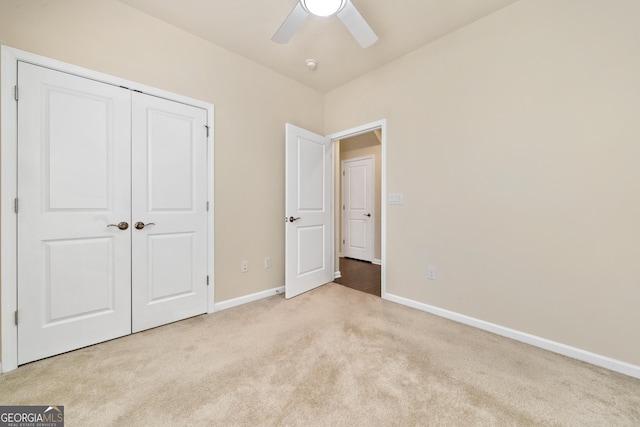 unfurnished bedroom featuring ceiling fan, a closet, and light colored carpet