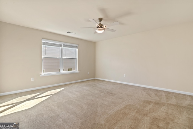 carpeted spare room featuring ceiling fan