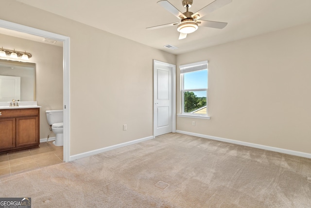 unfurnished bedroom featuring ensuite bathroom, ceiling fan, and light carpet