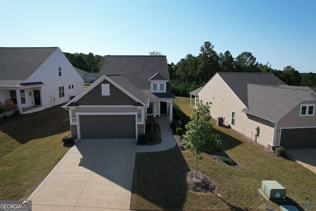 view of front of property with a front lawn, a garage, and cooling unit