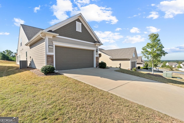 view of front of house with central AC unit, a garage, and a front lawn