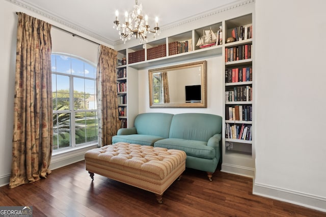 living area with a notable chandelier, ornamental molding, dark hardwood / wood-style flooring, and built in features