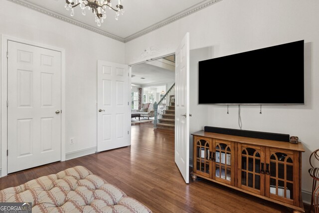 living room featuring ornamental molding, a chandelier, and dark hardwood / wood-style flooring