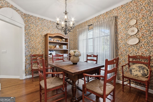 dining space featuring crown molding, wood-type flooring, and an inviting chandelier