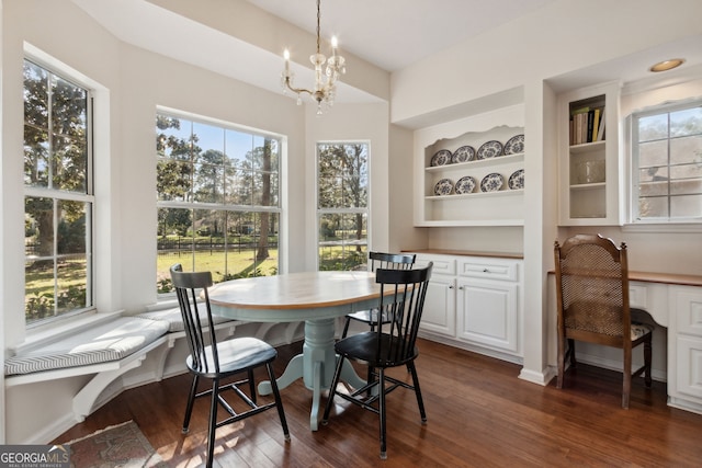 dining area with a healthy amount of sunlight, dark hardwood / wood-style flooring, and an inviting chandelier